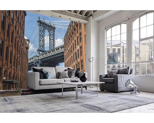 Salon avec papier peint photo représentant un pont et des bâtiments, avec canapé, fauteuil et tapis