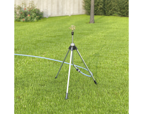 Arroseur de pelouse sur un trépied dans le jardin