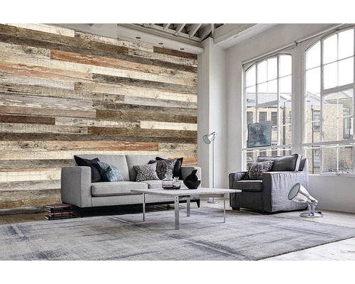 Salon avec panneaux muraux imitation bois, canapé, fauteuil et tapis pour une ambiance chaleureuse.