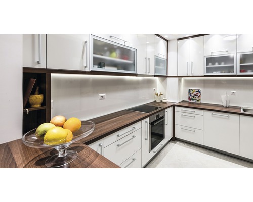 Helle Küche mit weißen Schränken, dunklen Arbeitsplatten und integrierten Geräten für ein modernes Design