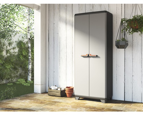Gartenschrank aus Kunststoff mit zwei Türen vor einer Holzwand