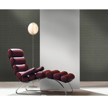 Interieuransicht mit Sessel, Stehlampe und gemusterter Tapete.