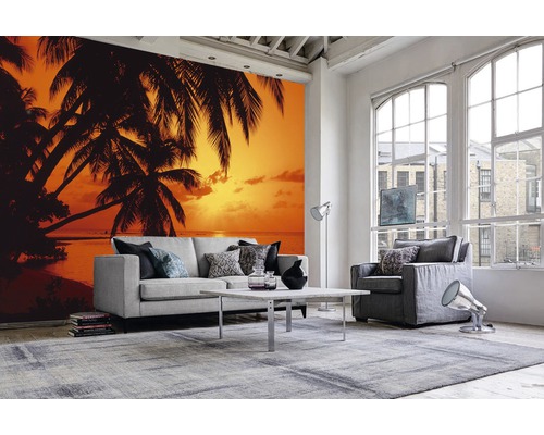 Salon avec papier peint photo motif palmier et coucher de soleil sur la plage, canapé, fauteuil, tapis et table basse