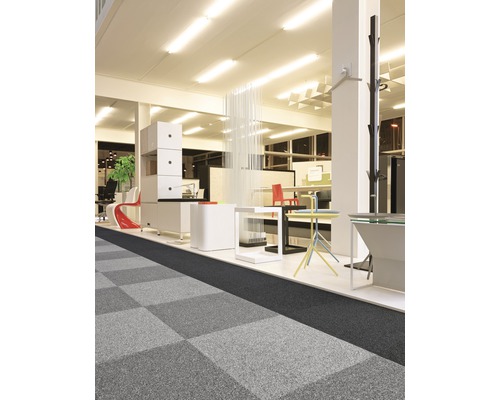 Büroraum mit Teppichfliesen in Schachbrettmuster, Regalen und Büromöbeln.