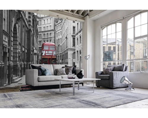 Wohnzimmer mit Sofa, Sessel, Teppich und Fototapete mit Londoner Stadtmotiv