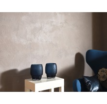 Intérieur avec mur en crépi structuré, deux vases décoratifs et un fauteuil