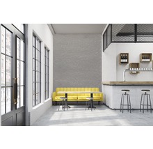 Intérieur avec bar, canapé jaune et tables.