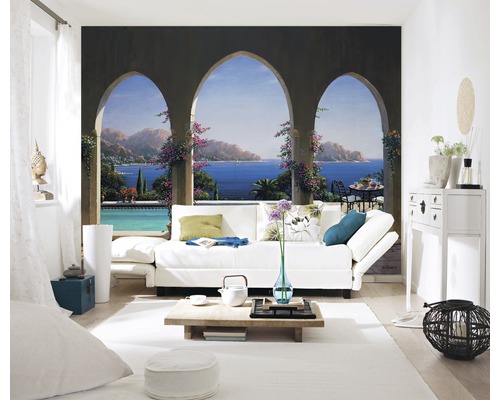 Salon lumineux avec fresque murale, canapé, table et décorations.