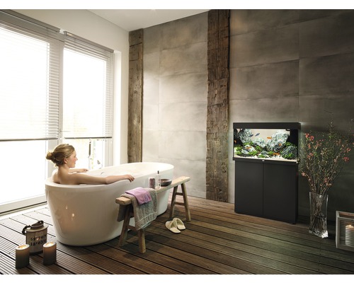 Salle de bains avec baignoire îlot, aquarium et plancher en bois pour une ambiance relaxante
