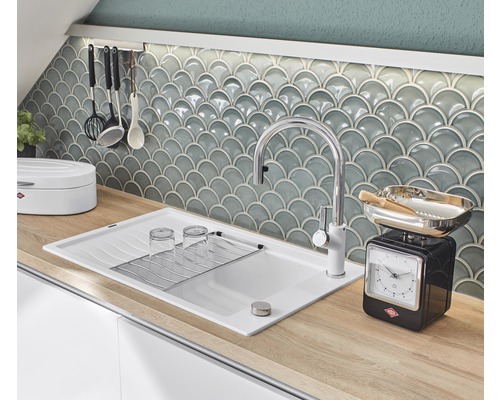 Scène de cuisine avec évier, robinet, vaisselle et balance de cuisine