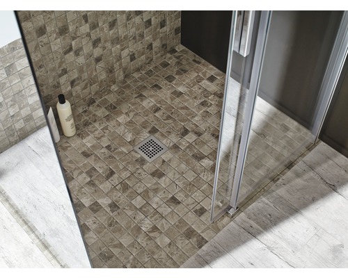 Gros plan d''une douche avec mosaïque, cabine de douche et drain