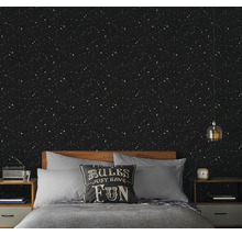 Chambre à coucher avec papier peint ciel étoilé, lit et tables de chevet.
