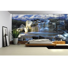 Wohnzimmer mit Fototapete Wasserfall-Motiv, Bett und Zimmerpflanze
