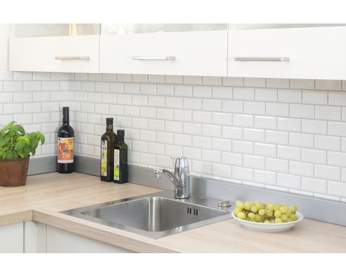 Küchenszene mit Spüle, Armatur, Fliesen und Küchenutensilien