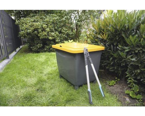 Scène de jardin avec composteur et sécateur sur une pelouse