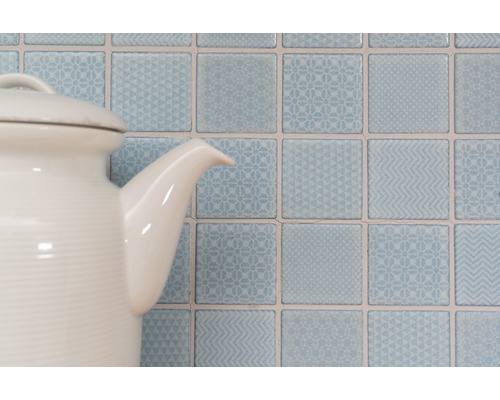 Carreaux muraux carrés décoratifs avec motifs derrière une théière