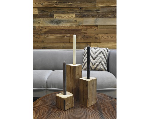 Dekorative Anordnung mit Kerzen und Holzständern auf einem Tisch.