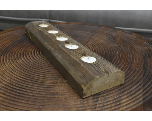 Dekorative Teelichthalterung aus Holz mit fünf Teelichtern auf einem Tisch