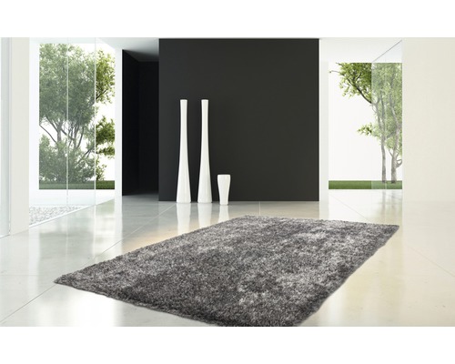 Grauer Teppich in einem hellen, modernen Raum mit weißen Vasen und Blick ins Freie