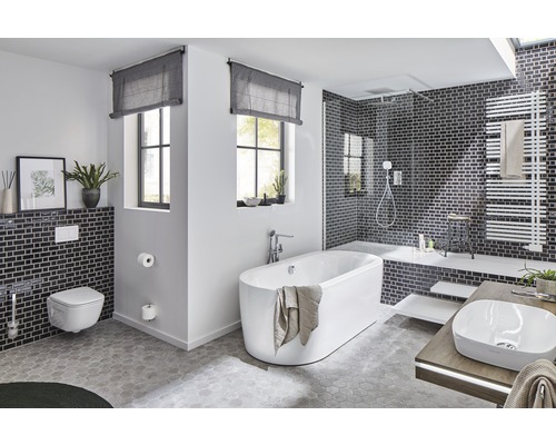 Salle de bains lumineuse avec baignoire, lavabo, toilettes et douche