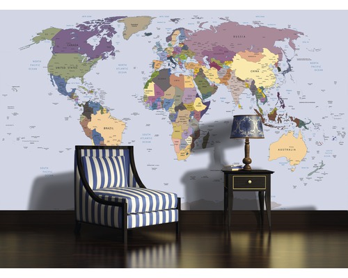 Papier peint représentant une carte du monde, fauteuil rayé et table de chevet avec lampe dans une pièce lumineuse