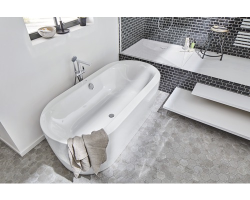 Salle de bain lumineuse avec baignoire îlot, douche et espace de rangement