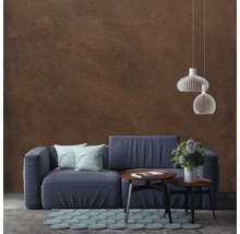 Salon avec un canapé bleu, une table basse, un tapis et des suspensions devant un mur
