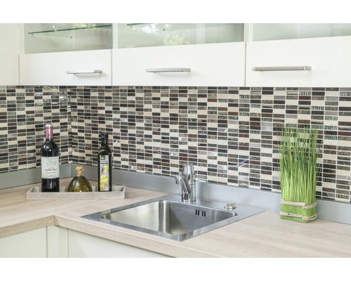 Küchenspüle mit Armatur, Mosaikfliesen und Dekorationen auf einer Arbeitsplatte.