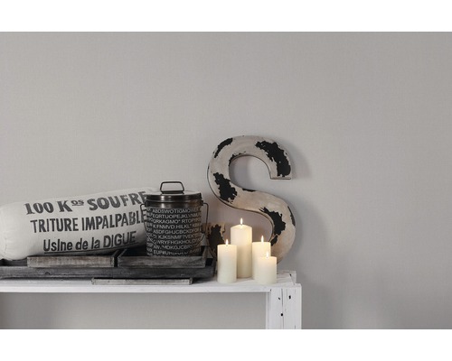 Scène décorative avec coussin, boîte, lettres et bougies sur une étagère