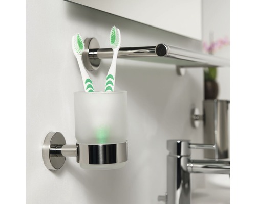 Wandhalterung mit Zahnputzbecher aus Glas und zwei Zahnbürsten im Badezimmer.