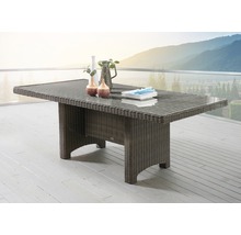 Table de jardin en polyrotin sur une terrasse avec vaisselle et décoration
