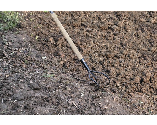 Fourche de jardin avec manche en bois dans le sol