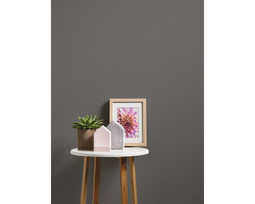 Dekorative Szene mit Pflanze, Häusern und Bilderrahmen auf einem Tisch.