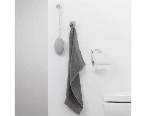 Vue de salle de bains avec serviette, porte-papier toilette et décoration