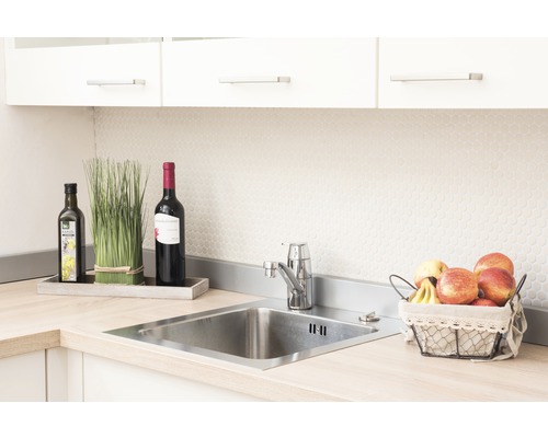 Évier de cuisine en acier inoxydable avec robinet, entouré de décoration et de nourriture.