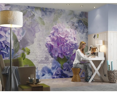 Wohnzimmer mit Blumentapete, Schreibtisch und sitzender Frau