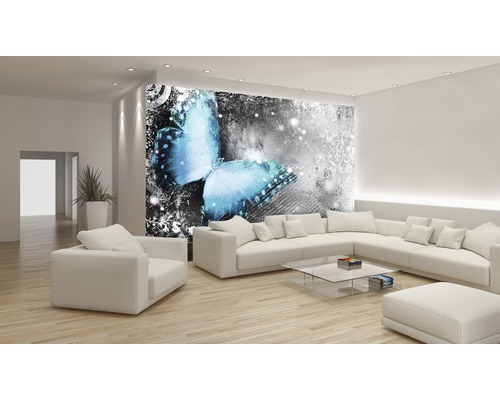 Salon avec papier peint photo à motif de papillon, mobilier clair et plancher en bois.