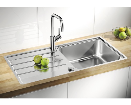 Spültisch aus Edelstahl mit Abtropffläche und Armatur auf einer Arbeitsplatte