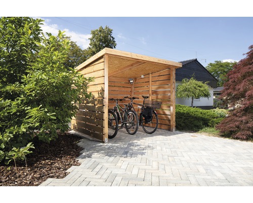 Offener Fahrradunterstand aus Holz mit zwei Fahrrädern auf gepflastertem Untergrund