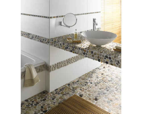 Badezimmer mit Waschtisch, Spiegel, Badewanne und Boden aus Kieselsteinen