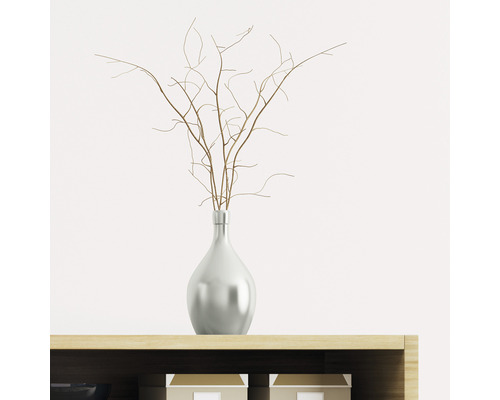 Branches décoratives dans un vase sur une armoire