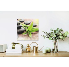 Toile décorative avec bambou et pierres sur un mur