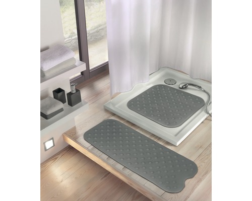 Salle de bains avec receveur de douche et tapis de douche gris.