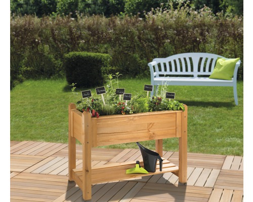 Jardinière sur pieds en bois avec étiquettes de plantes, arrosoir et outils de jardin dans le jardin