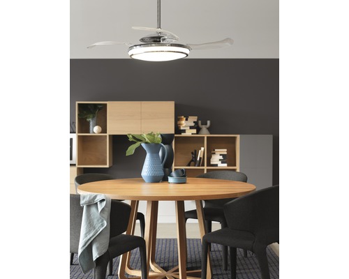 Salle à manger avec table ronde, chaises et ventilateur de plafond avec éclairage