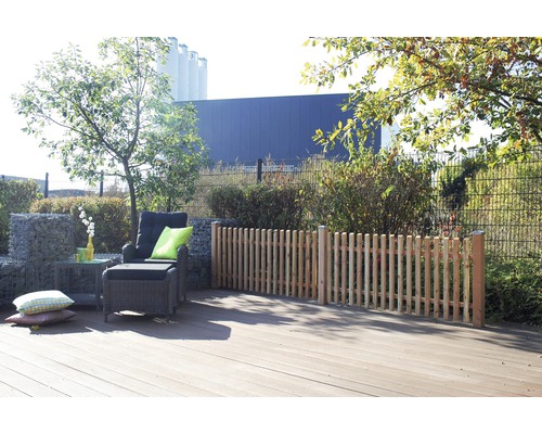 Terrasse avec platelage en bois, fauteuil lounge et clôture en palissade