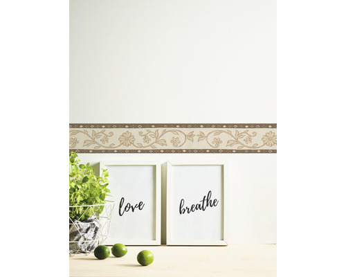 Pièce avec bordure florale et objets de décoration.