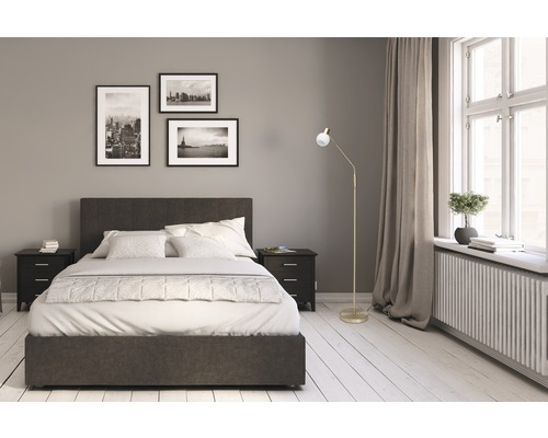 Chambre avec lit, tables de chevet, lampadaire et photos décoratives au mur