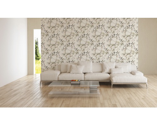 Salon avec papier peint à motifs floraux, canapé et table en verre