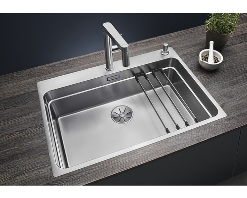 Évier en acier inoxydable avec égouttoir, robinet et distributeur de savon sur un plan de travail